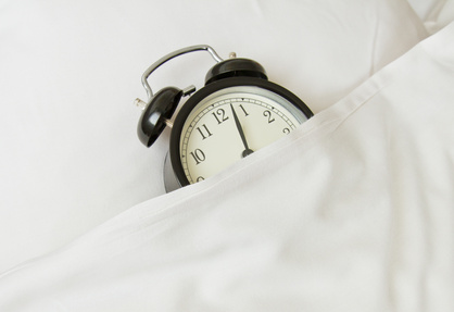 alarm clock sleeping in white linen bed