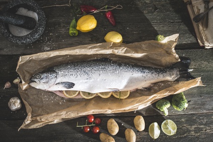 fish on cutting board surrounded by vegetables