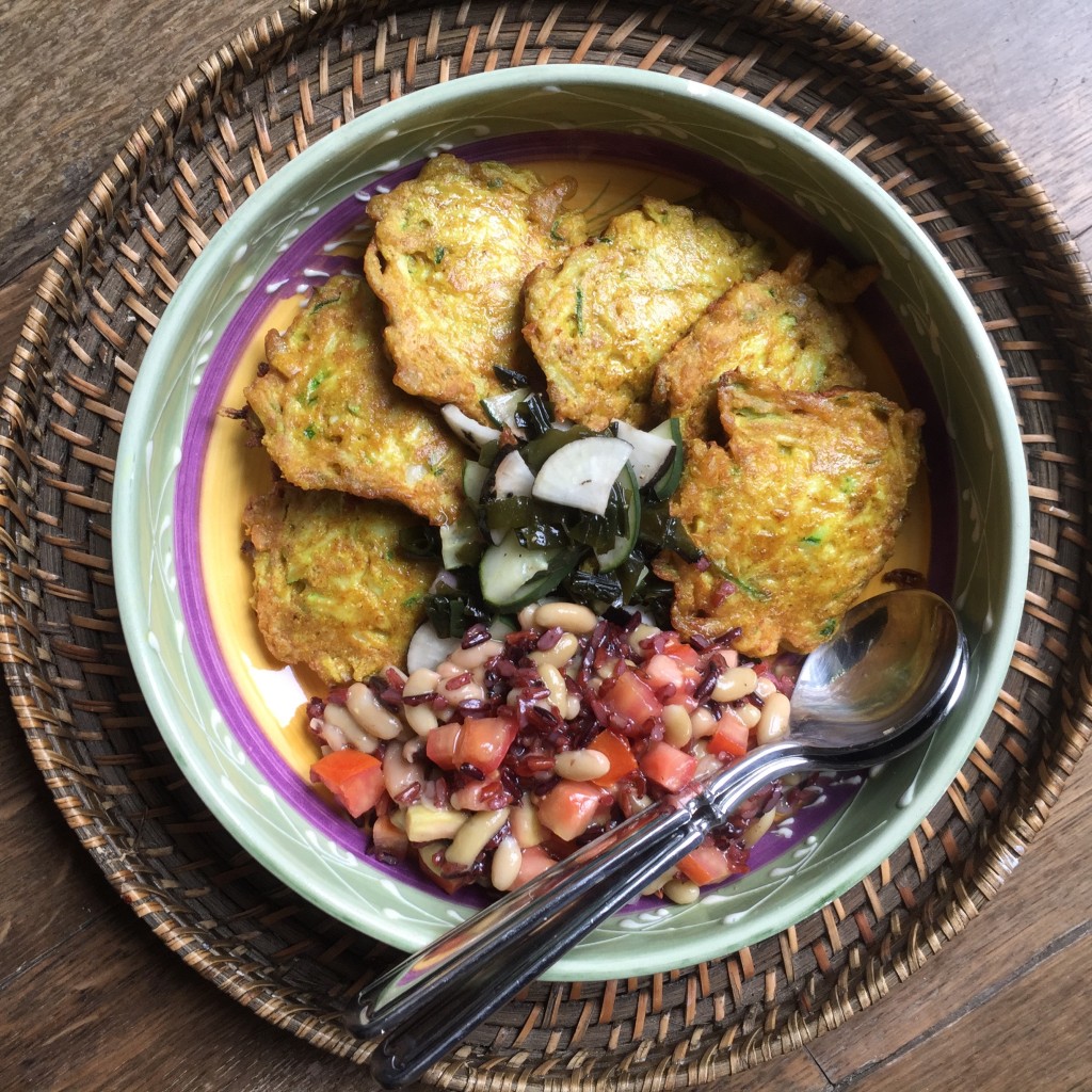 indian vegetable pakoras and beans on a plate on a wooden backgroun