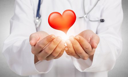 Close view of female doctor holding with care red heart