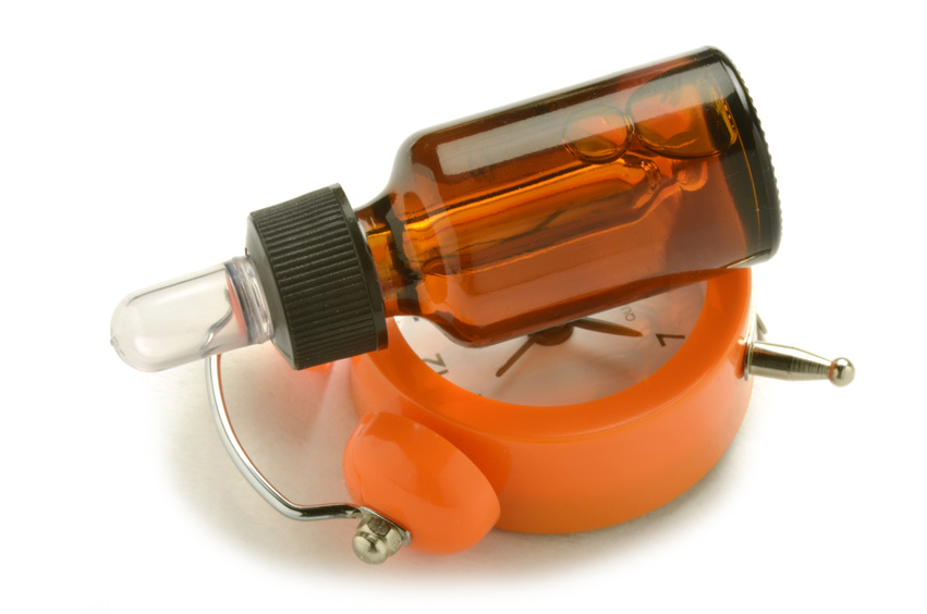 alarm clock with a glass bottle on top of it on a white background