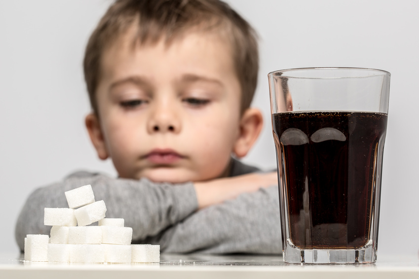 Glass full of soft drink, next to it is the amount of sugar used in it