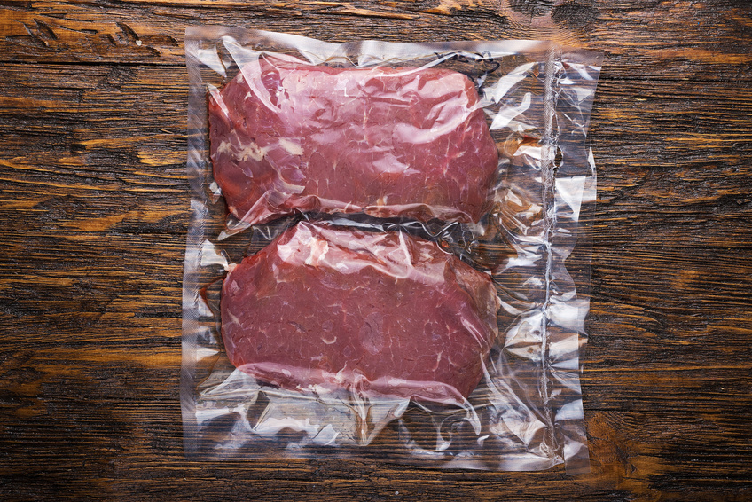 raw meat vacuum-packed, two steaks on a wooden board histamine