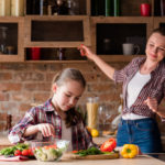 healthy family eating lifestyle. mom and daughter preparing vegetable salad.